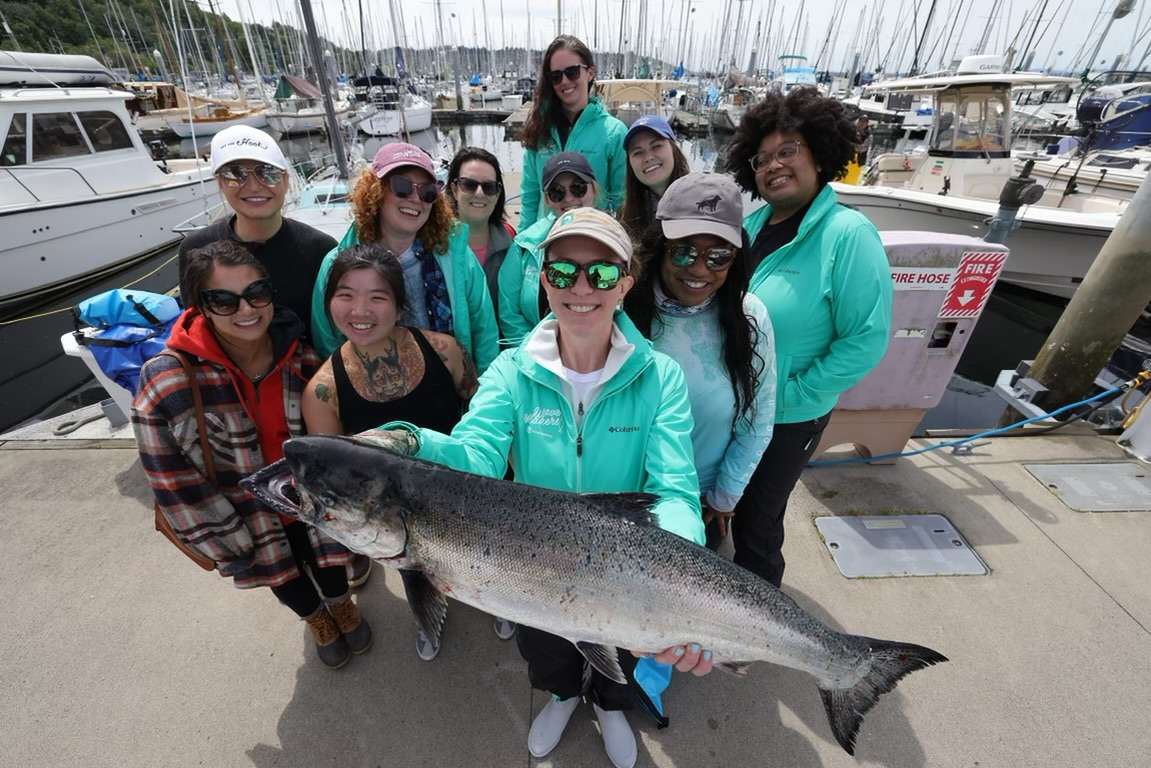 Group of people smiling after a successful fishing charter in Seattle